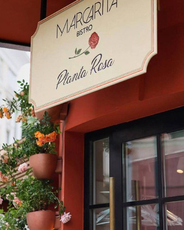 Вывеска Margarita Bistro с логотипом Planta Rosa у входа: цветы в горшках и вывеска в ретро-стиле, городская уличная сцена Патриарших.
