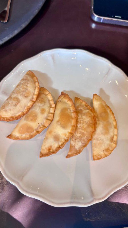 Порция чебуреков с икрой на белой тарелке: аккуратно обжаренные мини-чебуреки, ровная аппетитная корочка и простой минималистичный сервиз.