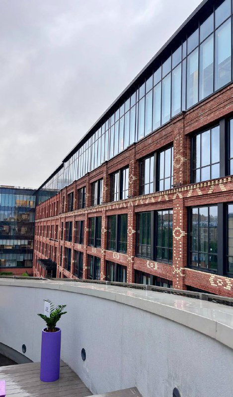 Фасад современного кирпичного здания музея с большими окнами и внешним видом двора, архитектурный ракурс здания.