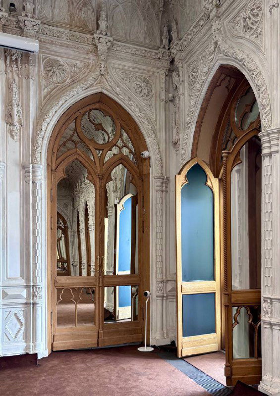 Зеркальные панели и неоготические арочные дверные проемы с позолоченными рамами в одном из залов усадьбы на Мясницкой