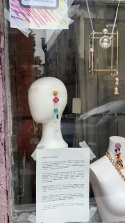 Витрина или перформанс с манекеном и яркими украшениями; бюст украшен странными аксессуарами в стиле мультфильмов, городская инсталляция.