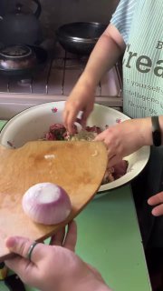 Мамины руки на кухонной доске: мелкие нарезки и лук для фарша, рядом миска с подготовленными ингредиентами — домашняя готовка шашлыка.