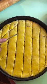 Разрезание заготовки на ромбики ножом перед выпеканием — видна ровная сетка разрезов на поверхности теста.