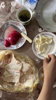 Столовая сцена: лаваш, нарезанный сыр, чашка травяного чая и руки за столом — деревенский завтрак или лёгкий перекус в семейной обстановке.