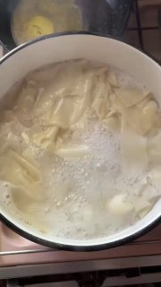 Кусочки теста в кипящей воде — вид процесса варки ленивых вареников, белые плавающие кусочки и пенная поверхность.