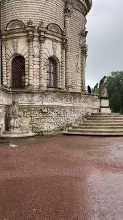 Фрагмент наружной стены усадебного храма с барельефами и потертостями камня, акцент на изящной скульптурной отделке.