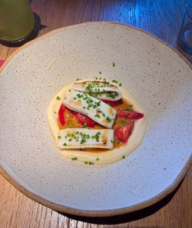 Тонко сервированное блюдо с кремовым соусом, ломтиками сыра и помидорами на глубокой тарелке в спокойной подаче Tacobar