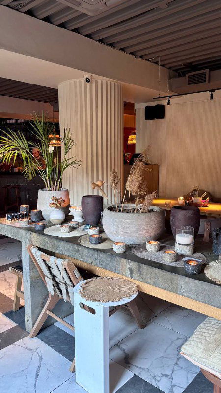 Декоративный стол с керамическими чашами и предметами интерьера в ресторане; отражение стильного дизайна и тёплой атмосферы Tacobar