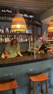 Барная зона Tacobar: бармены за стойкой, полки с бутылками и приглушённый свет — атмосферный вид заведения в центре Москвы