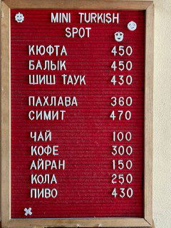 Доска меню Mini Turkish Spot с белыми буквами на красном фоне: кюфта, балык, шиш тау, пахлава, симит и напитки с ценами.