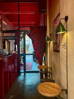 Интерьер Mini Turkish Spot: узкий красный коридор, ковры, лампы, барная стойка и небольшие столики — атмосферный уютный формат.