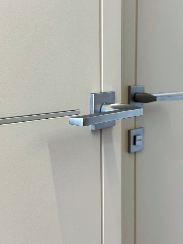 Крупный план дверной ручки и алюминиевого молдинга модели LINE 10: хромированный оттенок, точная отделка и архитектурная деталь вблизи.