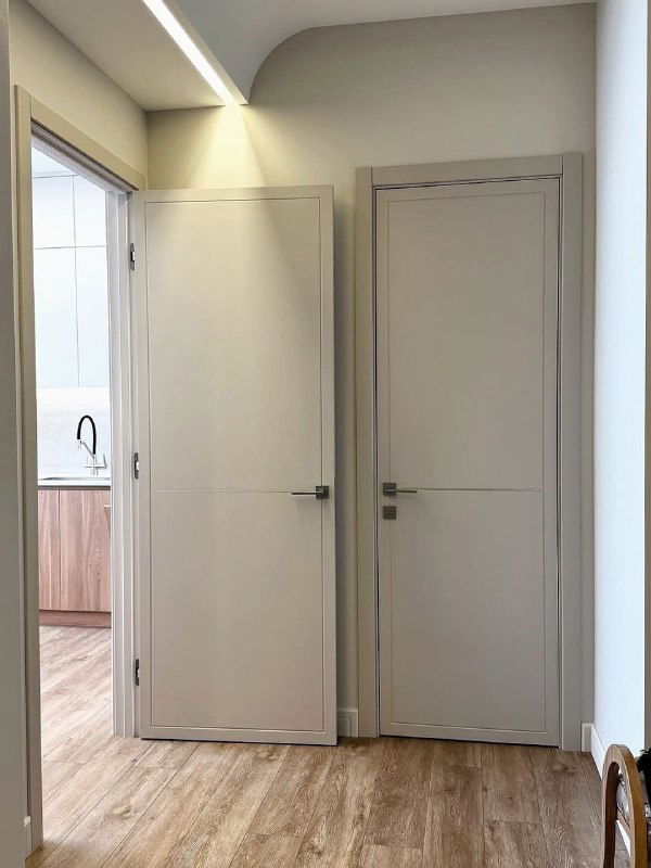 Две двери модели LINE 10 в коридоре: аккуратные зазоры между полотнами, лаконичные линии и нейтральная палитра, демонстрирующие серию в жилом интерьере.