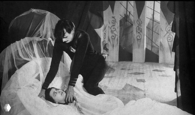 Мужчина над спящей женщиной в кровати — сцена сомнамбулизма и напряжения, характерная для сюжетной линии фильма 1920 года.