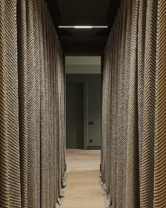 Узкий проход с тяжелыми текстильными шторами и деревянным полом, создающий ощущение уединения и продолжение лесной темы в интерьере.