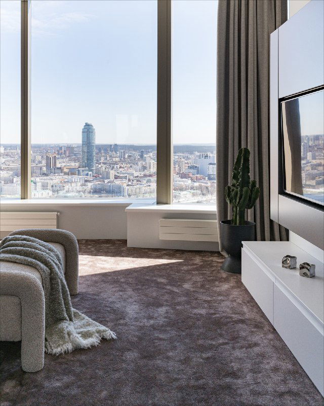 Панорамное окно и городской вид из спальни, мягкое ковровое покрытие «Мираж», низкая тумба под ТВ и текстуры в нюансах бежевого и серого.