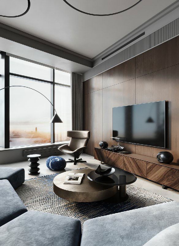 Уютный угол гостиной с панорамным окном, шпонованной деревянной стеной, креслом для отдыха, круглым журнальным столиком и синим пуфом на полу.