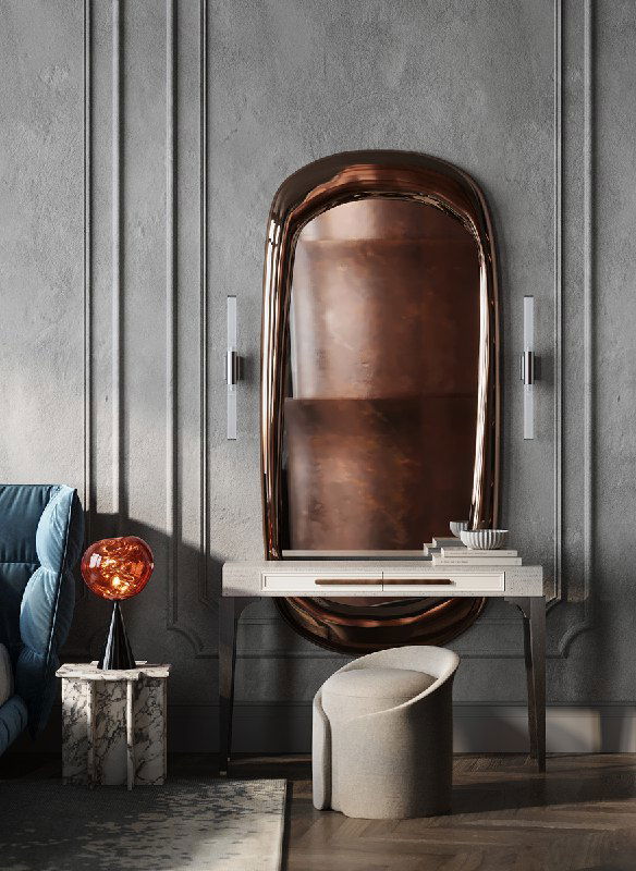 Макияжный столик с лаконичным пуфом и большим зеркалом в медной раме на фоне неоклассической отделки и декоративной подсветки в спальне.