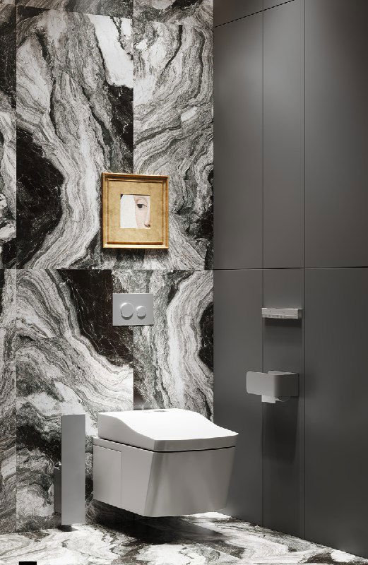 Крупный план на унитаз и нишу с маленькой картиной в золотой раме на фоне мраморно-ориентированного керамогранита и скрытых инженерных фасадов МДФ.