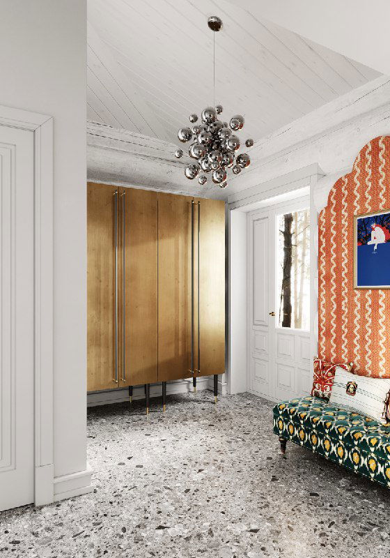 Вид прихожей с фокусом на золотой шкаф и яркую кушетку; металлическая люстра и входная дверь, белая обработка бревенчатых стен и фактурный пол в каменной гамме.