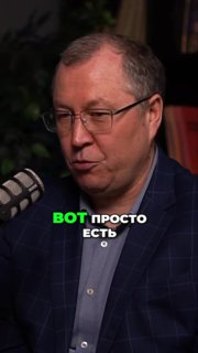 Крупный план мужчины в очках у микрофона, кадр из подкаста о приемке квартир; тёмный фон и зелёная текстовая надпись поверх изображения