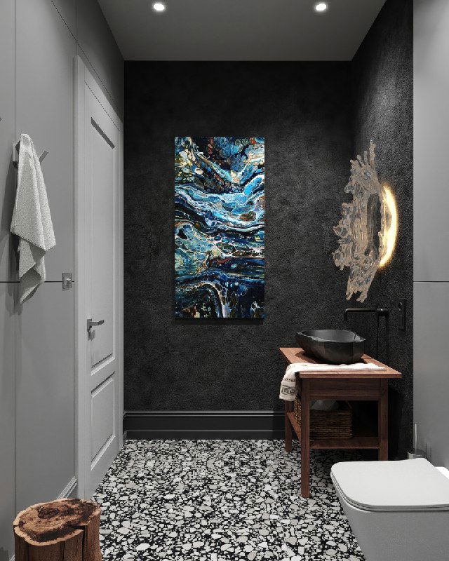 Вид от двери: панно над тумбой, текстурная черная стена и зеркало‑бра напоминающее застывшие брызги, деревянная тумба и каменная раковина.