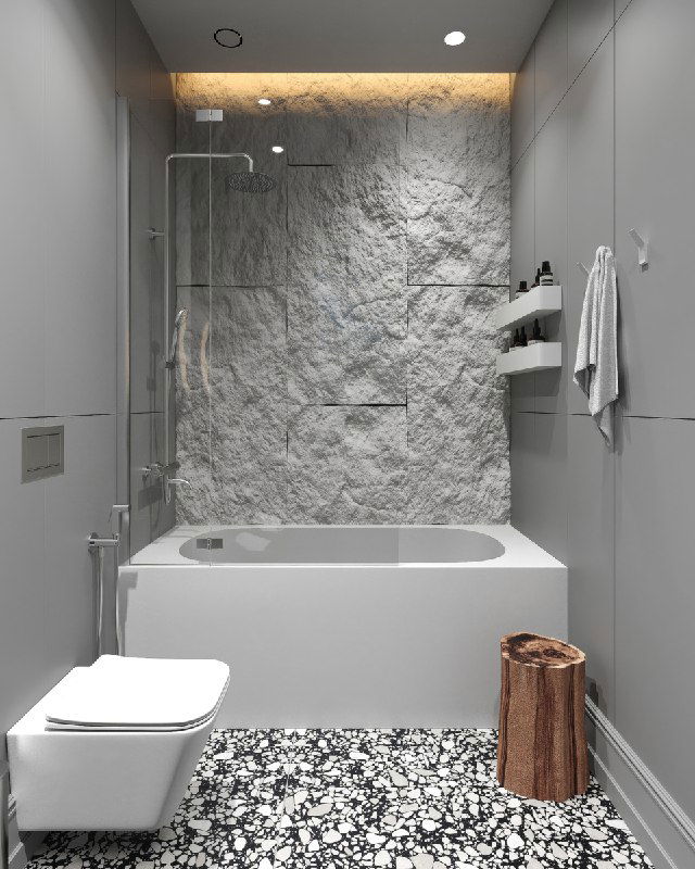 Фрагмент стены с каменной фактурой за ванной, аккуратная ниша для хранения, встроенная подсветка и монохромные панели вокруг ванны.