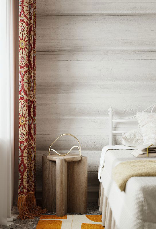 Деталь интерьера: портьеры с орнаментом, мягкая палитра текстиля и низкая деревянная прикроватная тумба на фоне светлой фактуры стен.