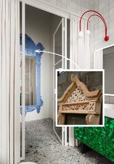 Детальный снимок резного наличника и отделки коридора в бревенчатом доме: деревянная резьба готовится к покраске и установке зеркала.