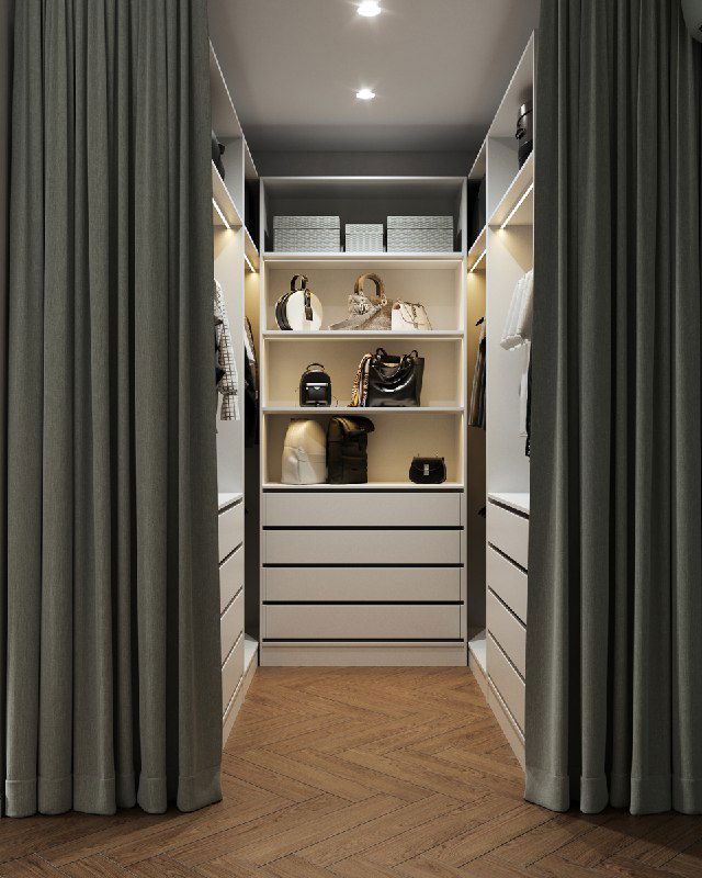 Вид в гардеробную за зелёной бархатной шторой: организованные полки и ящики с сумками и коробками, проход и деревянный тёплый паркет.