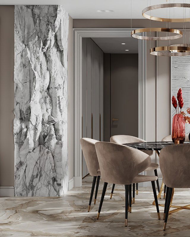 Крупный план декоративной колонны с рельефной фактурой, встроенной в проем между прихожей и кухней, на фоне обеденной зоны и текстурных стен с молдингами.