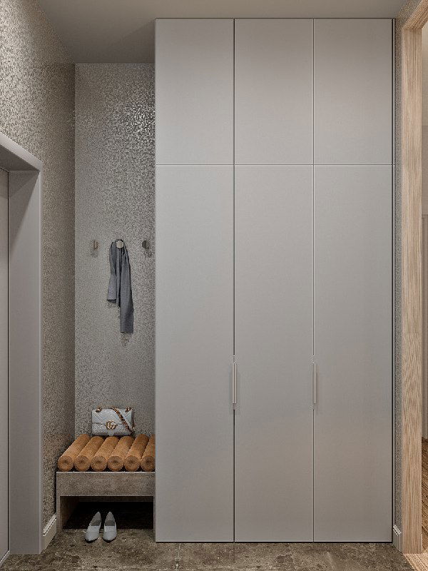 Шкаф и мини-банкетка в терракотовых тонах, встроенный шкаф для верхней одежды замаскирован под стену — вид слева от входа.