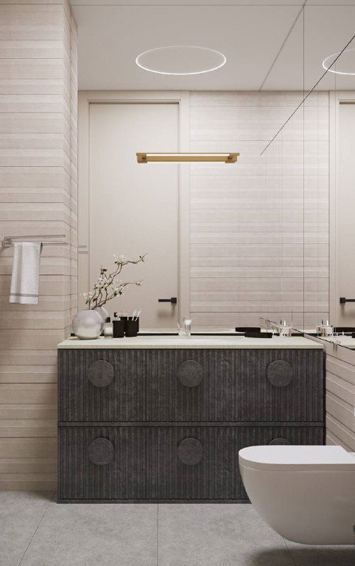 Сдержанная светлая умывальная зона в бежевых тонах с минималистичной тумбой и встроенным светом, чистые линии и лаконичная отделка для компактного пространства.