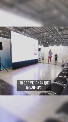 Фото зала лекции: сцена с большим белым экраном, несколько человек у экрана и ряды подготовленных кресел — контекст выступления на форуме по недвижимости.