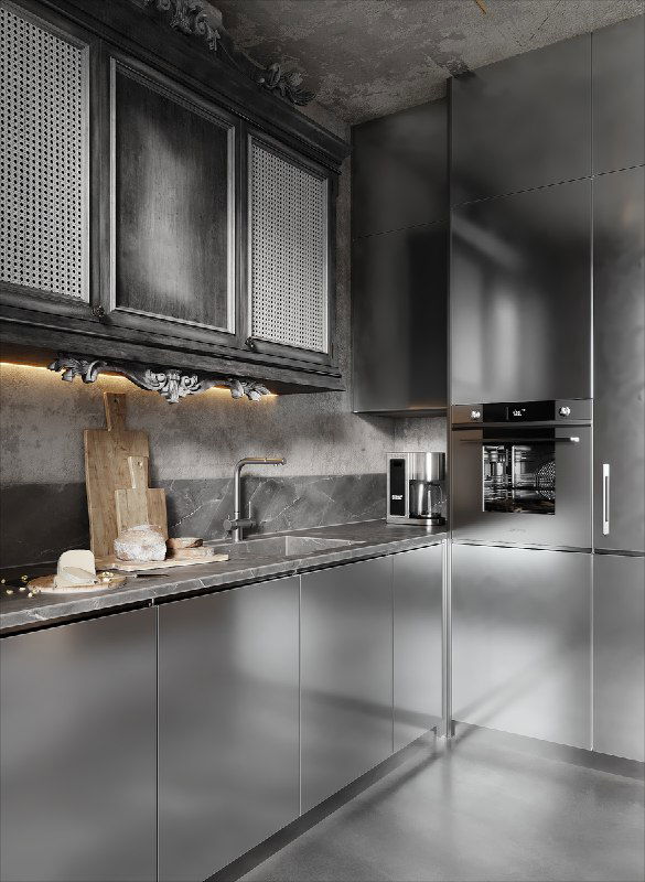 Крупный план кухонного гарнитура: металлические фасады, встроенная техника и резной навесной шкаф на фоне строгой серой стены.