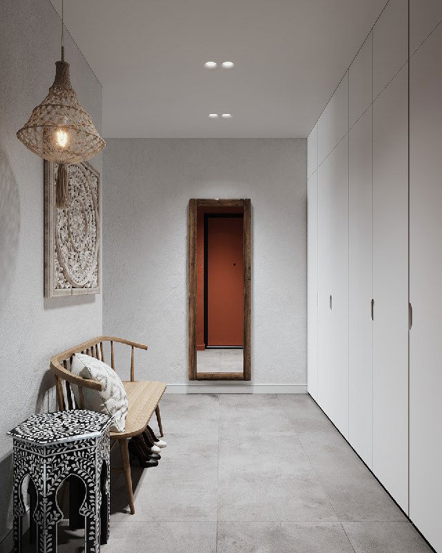 Длинная перспектива прихожей: белые встроенные шкафы вдоль стены, в конце ростовое зеркало в деревянной раме напротив входа, пол плитка серого тона.