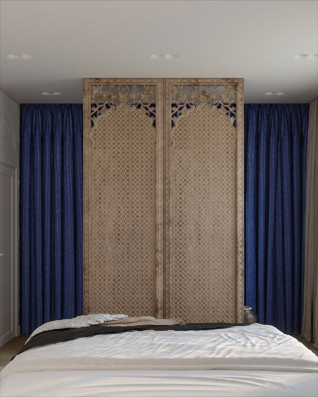 Ширма‑разделитель из резного дерева между зоной кровати и гардероба с плотными синими шторами за ней и текстильными акцентами на кровати.