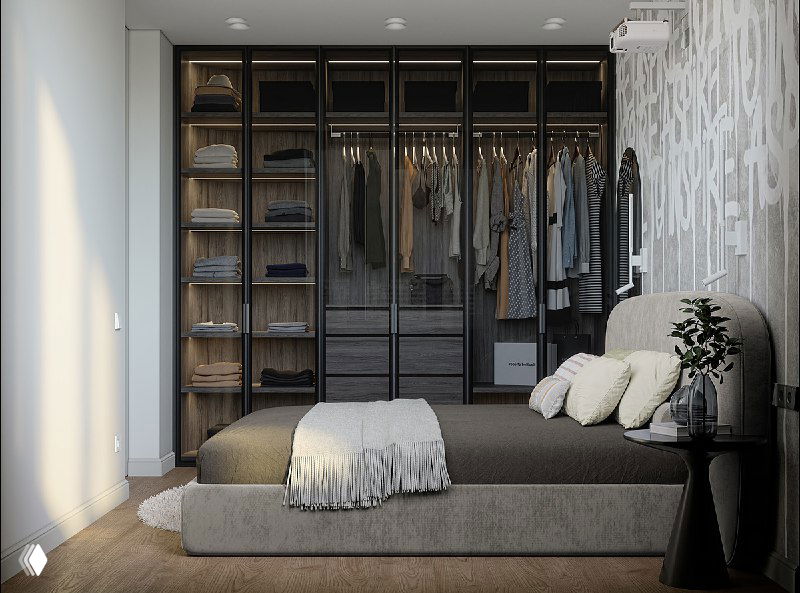 Шкаф во всю стену со тонированными стеклянными фасадами, внутренним освещением и аккуратно развешенной одеждой.