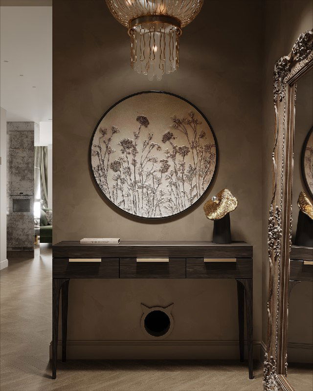 Консоль под круглой цветочной гипсовой панелью, декоративный граммофон, крупная зеркальная рама и золотая люстра в оформлении прихожей проекта