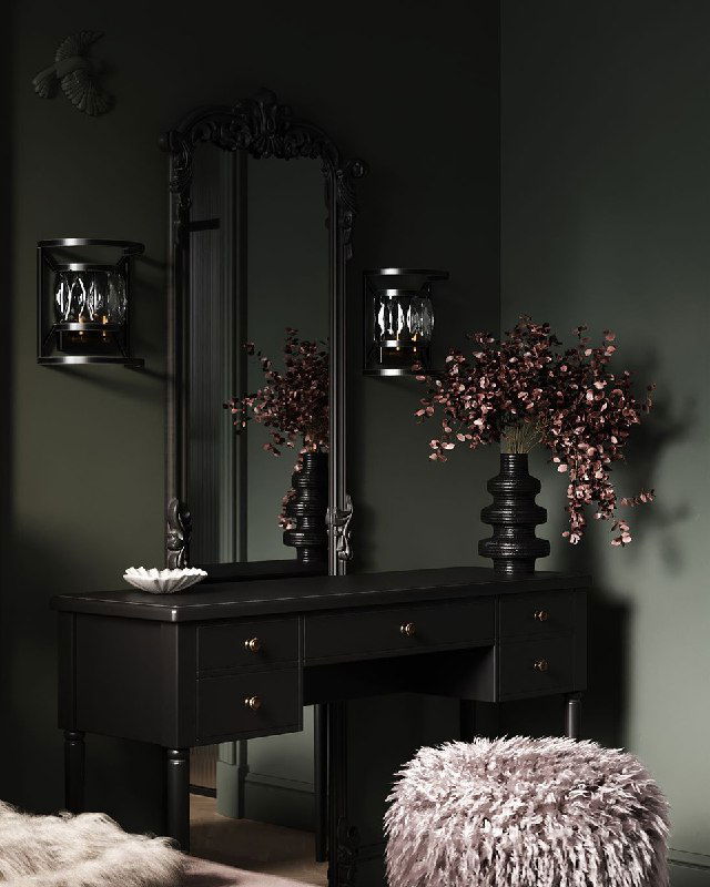 Темное готическое зеркало с резной рамой над консолью, рядом декоративные вазы и мягкая пушистая табуретка в уютном углу.