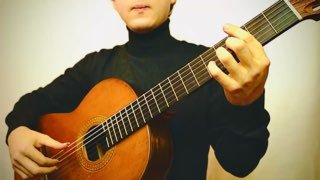 Гитарист в тёмном свитере играет на классической гитаре; видны руки, положение на грифе и корпус инструмента.