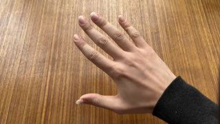 Правая рука гитариста на деревянной поверхности: вид ладони и пальцев, видно положение фаланг и направление движения.