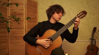 Гитарист в домашнем интерьере играет на классической гитаре — видна посадка, положение рук и инструмент, мягкое освещение, музыкальная обстановка.