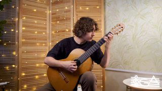 Человек играет на классической гитаре в уютной комнате с декоративными гирляндами и нотами рядом; крупный план рук и грифа.