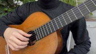 Кадр из обучающего видео: классическая гитара крупным планом, правая рука у струн и вид части грифа, демонстрация техники.