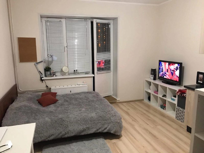 Спальная зона с кроватью и телевизором, простая и аккуратная обстановка — пример подготовки отдельно взятой комнаты перед показом.