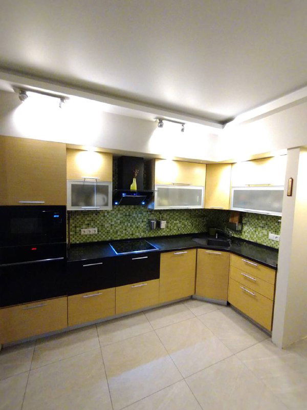 Угловая кухня после обновления фасадов и стайлинга: светлые шкафы, чёрная столешница и подсветка рабочей зоны перед съёмкой.