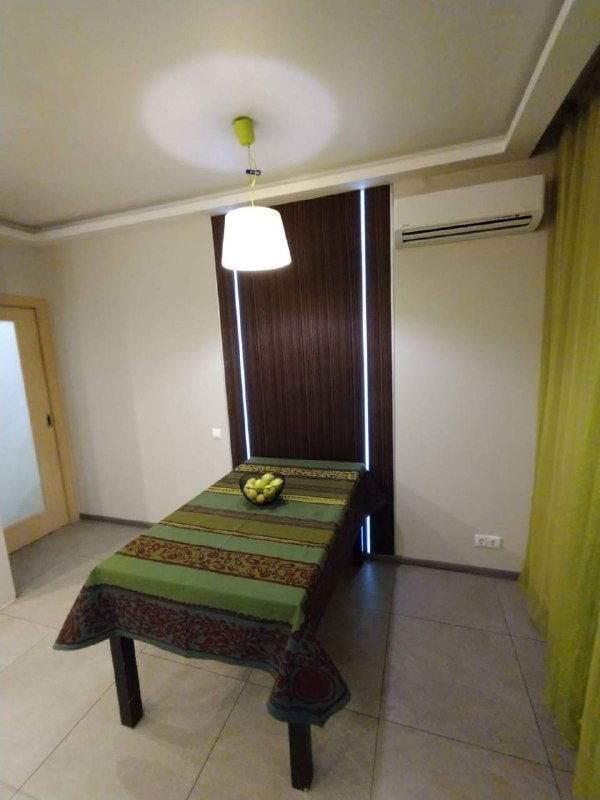 Небольшая столовая зона с обеденным столом и зелёными оттенками в интерьере, подготовленная для демонстрации функциональности жилья.