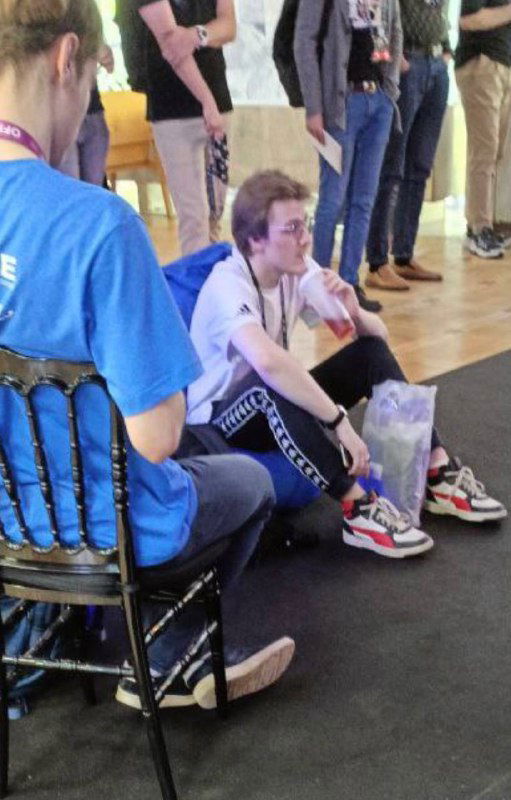 Участники отдыхают на полу конференц‑зоны OffZone 2024: разговоры и обмен впечатлениями между сессиями и стендами в неформальной обстановке.