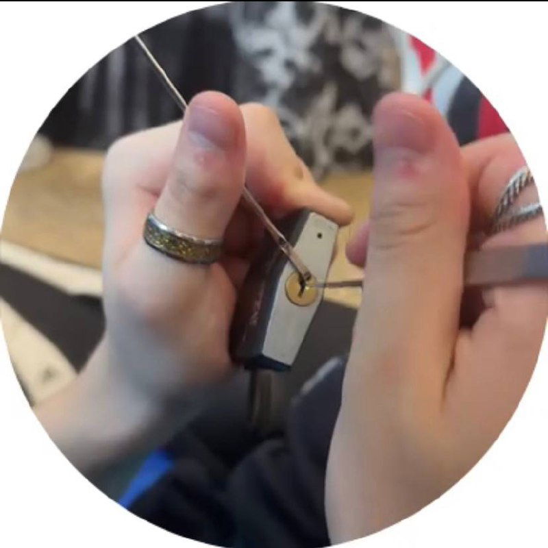 Крупный план рук с инструментами локпикинга и открывающегося навесного замка на стенде OffZone 2024, демонстрация практики и навыков.